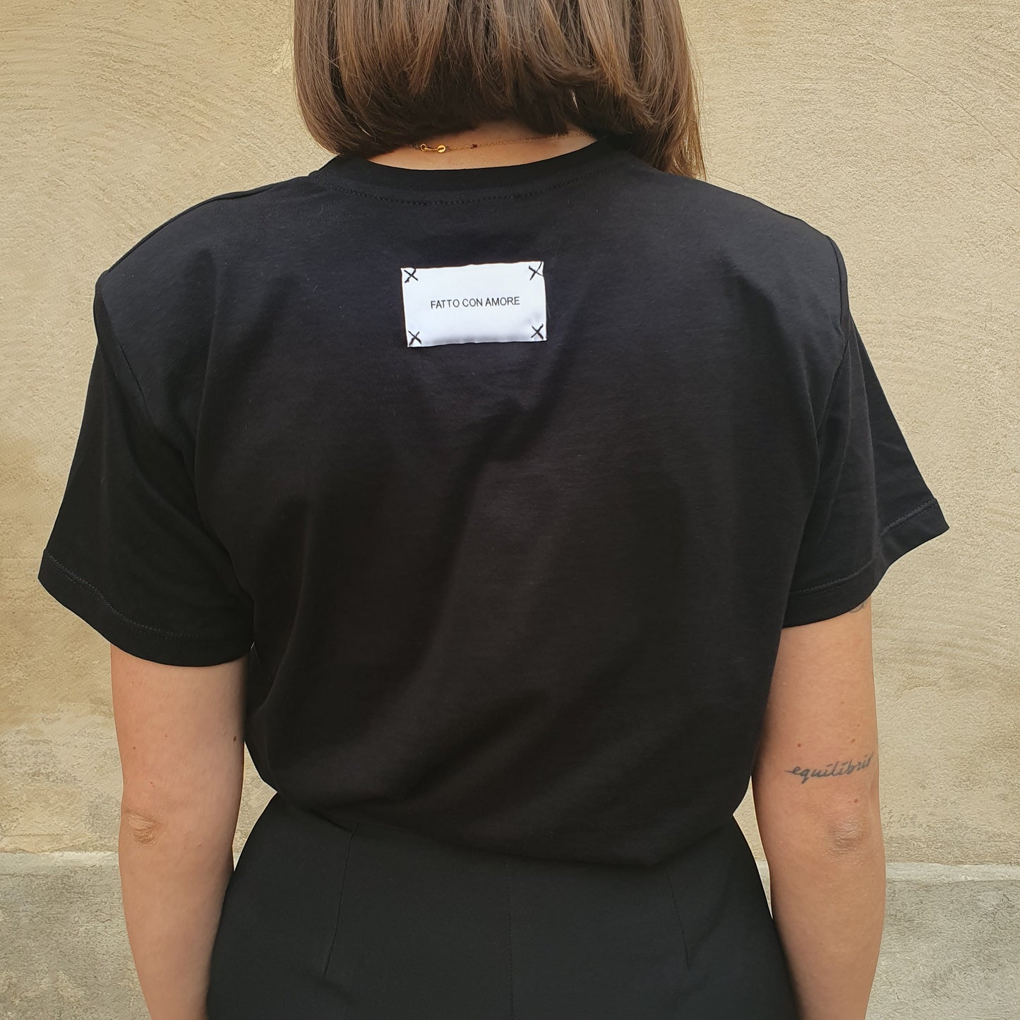 T-shirt nero con spalline imbottite e etichetta di Giulia Nati Couture, per uno stile unico e alla moda a Fossano