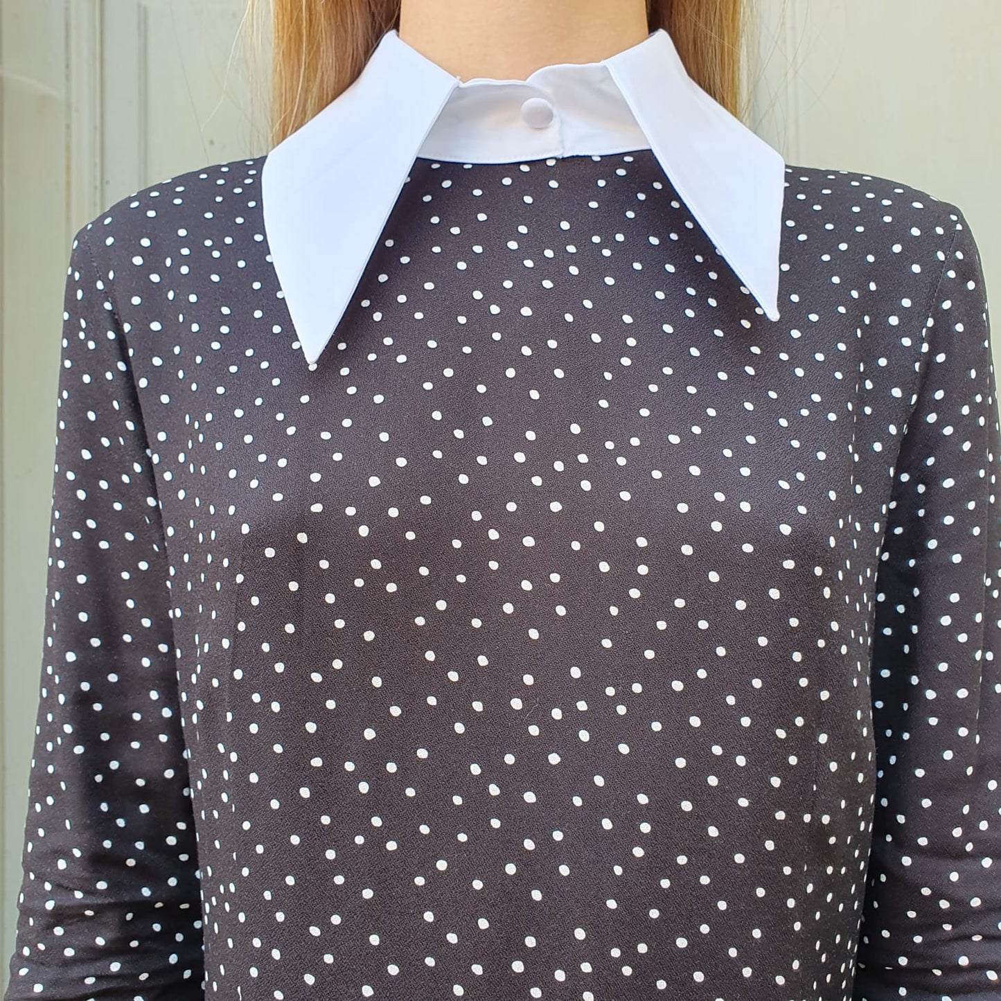 Abito lungo con colletto bianco da donna in tessuto viscosa a pois bianchi, perfetto per serate eleganti o eventi speciali. Disponibile a Fossano.